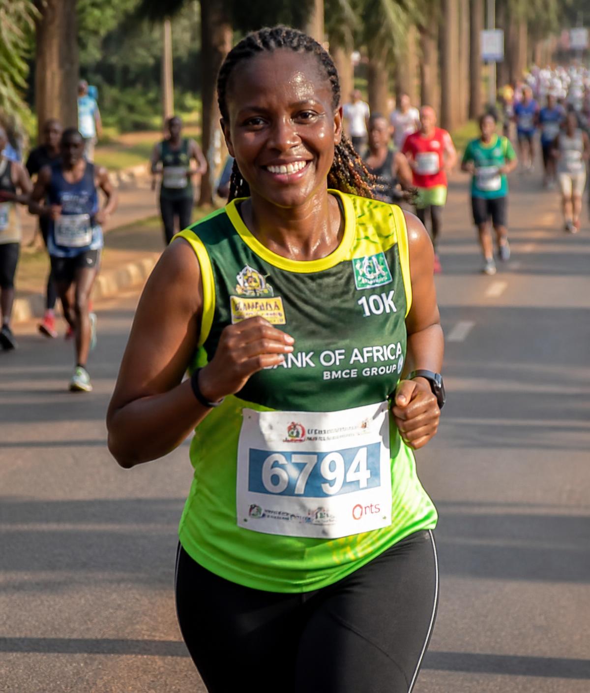 A smiling runner in the green and yellow Harambe Run vest on a tree-lined Kampala avenue